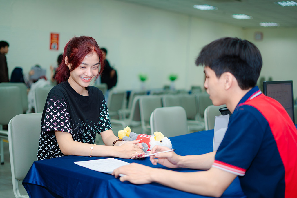 Á hậu cười rạng ngỡ trong khi nghe phổ biến về quy chế, lịch học và các hoạt động dành cho tân sinh viên HIU.