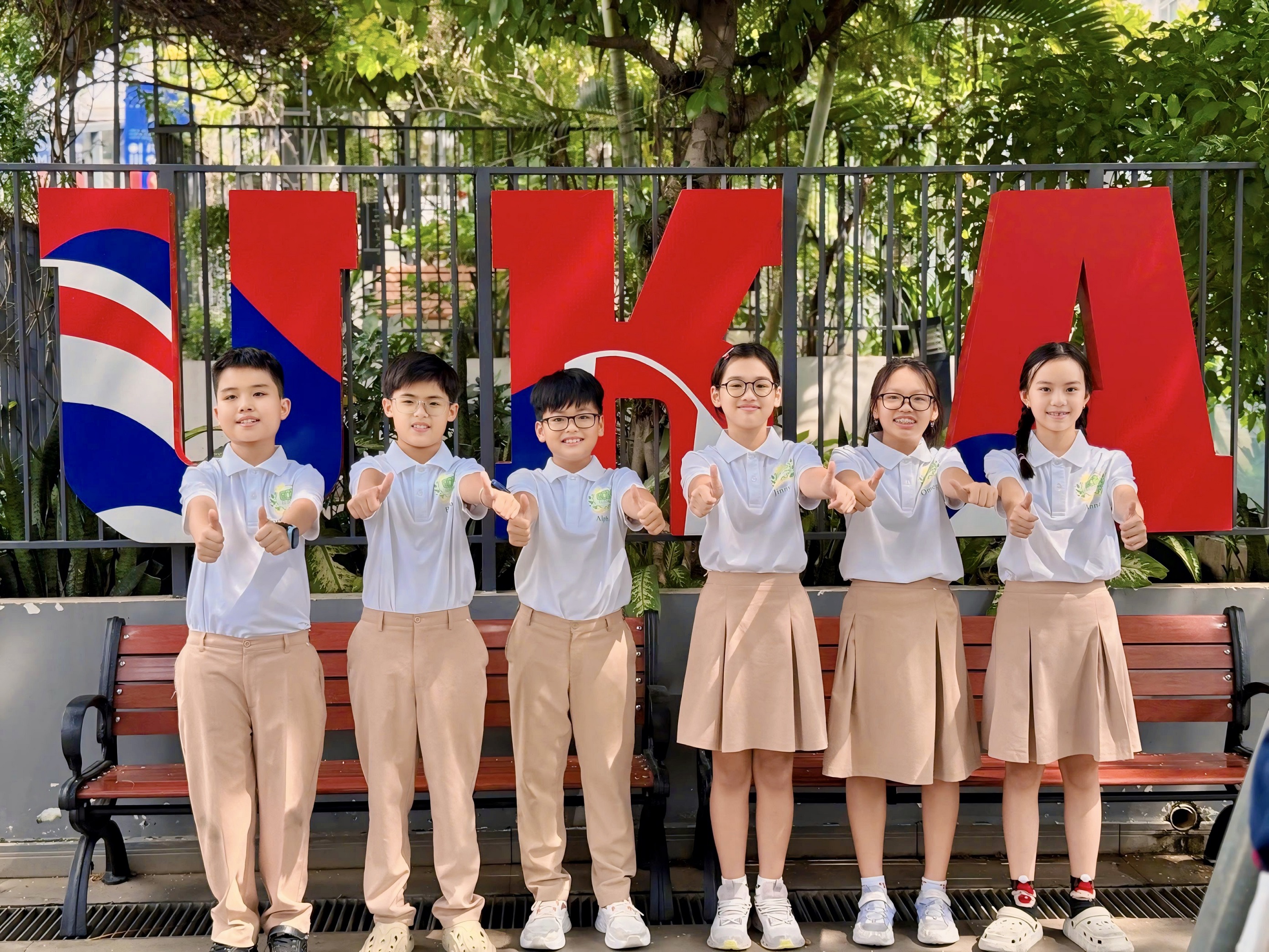 EcoBank – mô hình ‘ngân hàng tái chế xanh’ do học sinh UKA Bình Thạnh vận hành đã xuất sắc giành Giải Nhất Social Challenge 2025 khu vực châu Á - Thái Bình Dương. Dự án chinh phục ban giám khảo nhờ tính thực tiễn, khả năng tổ chức như một ngân hàng thật và tác động giáo dục – môi trường rõ rệt trong cộng đồng học đường Social Challenge 2025 là vòng thi tổng kết của chương trình JA SparktheDream – dự án giáo dục tài chính do Junior Achievement Asia Pacific và Tập đoàn FWD phối hợp triển khai tại nhiều quốc gia trong khu vực. Đây là sân chơi uy tín dành cho học sinh 10–14 tuổi, nơi các em vận dụng tư duy tài chính để đề xuất giải pháp cho những vấn đề xã hội bức thiết. Cuộc thi năm nay thu hút học sinh từ nhiều quốc gia châu Á–Thái Bình Dương, những đại diện được tuyển chọn sau nhiều vòng thi cấp trường và cấp quốc gia. Để chiến thắng, các đội thi phải chứng minh khả năng phân tích vấn đề, sáng tạo ý tưởng, thiết kế mô hình hoạt động và đặc biệt là tính thực tiễn của giải pháp. Trong bối cảnh đó, dự án EcoBank – Ngân hàng Tái Chế Xanh của học sinh UK Academy Bình Thạnh đã vượt qua nhiều đối thủ quốc tế, gây ấn tượng mạnh nhờ mô hình rõ ràng, khả năng vận hành thực tế trong cộng đồng và hiệu quả giáo dục vượt ngoài khuôn khổ lớp học. EcoBank – Hành trình biến rác thải thành giá trị và giành giải thưởng quốc tế EcoBank bắt đầu từ một câu hỏi giản dị của học sinh: “Tại sao rác tái chế không thể trở thành giá trị?”. Từ suy nghĩ ấy, nhóm học sinh lớp 6.2 UKA đã đề xuất mô hình ngân hàng xanh, nơi mỗi chai nhựa, mỗi tờ giấy vụn hay món đồ cũ đều có thể được “gửi” để đổi lấy EcoCoins – đồng tiền nội bộ do chính các em tạo ra. Điều khiến EcoBank trở nên khác biệt nằm ở cách vận hành như một ngân hàng thật sự. Các em phát hành Bankbook – sổ tiết kiệm cá nhân, ghi nhận minh bạch từng giao dịch gửi – rút EcoCoins, thiết lập quy tắc tích lũy và tính “lãi suất”, thậm chí cho phép vay EcoCoins bằng hình thức tín chấp hoặc thế chấp. Chính sự mô phỏng chặt chẽ này giúp EcoBank trở thành một mô hình tài chính thu nhỏ đúng nghĩa. Không dừng ở hoạt động ngân hàng, EcoBank còn tạo vòng tuần hoàn giá trị: rác tái chế được phân loại, đưa đến đối tác thu mua để tạo nguồn tài chính vận hành dự án; đồng thời, học sinh tự tay tái chế chai nhựa, giấy, thủy tinh thành chậu hoa, hộp bút hay đèn trang trí để quy đổi quà tặng tại gian hàng EcoBank. Mỗi sản phẩm được tạo ra không chỉ mang ý nghĩa môi trường mà còn là minh chứng cho tinh thần sáng tạo và trách nhiệm của học sinh UKA.  Dự án nhanh chóng lan tỏa trong trường thông qua Ngày hội EcoBank, thu hút phụ huynh, giáo viên và học sinh toàn trường, tạo ra tác động cộng đồng thiết thực. Chính nhờ tính khả thi, cách tổ chức bài bản và hiệu quả giáo dục – môi trường hài hòa, EcoBank đã thuyết phục ban giám khảo để giành Giải Nhất Social Challenge 2025. JA tại UKA – Nền tảng nhiều năm giúp học sinh vững tư duy tài chính Đằng sau thành công của EcoBank là cả một hành trình dài mà UK Academy xây dựng thông qua việc triển khai chương trình Junior Achievement (JA) trong nhiều năm. JA là tổ chức giáo dục phi lợi nhuận lớn nhất thế giới về hiểu biết tài chính, khởi nghiệp và sẵn sàng nghề nghiệp cho học sinh, và UKA là một trong những hệ thống tiên phong áp dụng JA vào chương trình học thường xuyên. Nhờ JA, học sinh UKA được tiếp cận với tư duy tài chính thực tế từ sớm: hiểu giá trị đồng tiền, lập kế hoạch chi tiêu, phân tích rủi ro, quản lý nguồn lực, tư duy thiết kế giải pháp và phát triển tinh thần doanh chủ. Quan trọng hơn, UKA biến JA thành học qua trải nghiệm, nơi học sinh không chỉ nghe giảng mà được thực hành trong các mô hình tài chính, phiên chợ khởi nghiệp, dự án cộng đồng và các cuộc thi JA cấp quốc gia – quốc tế. EcoBank chính là minh chứng rõ nét nhất: khi được trang bị nền tảng tư duy đúng và môi trường thực hành thực tế, học sinh có thể tạo ra những mô hình tài chính – xã hội có giá trị thật, tạo tác động thật và đạt được thành tích quốc tế.